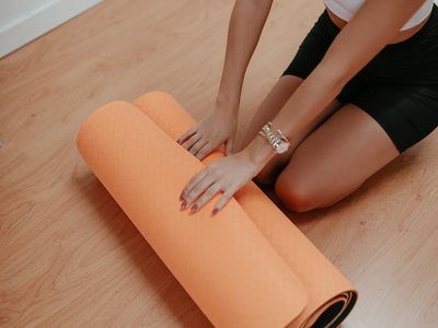 Minimalist yoga space with a wooden floor and mat.